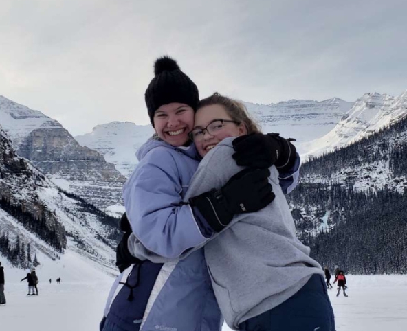 Friends hugging on snowfields in Canada